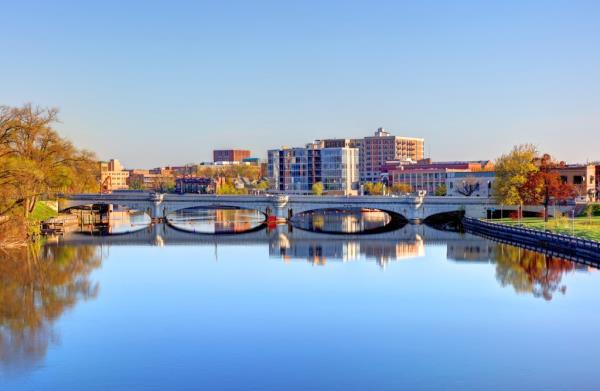Bridge over a body of water with cityscape of South Bend, Indiana in the background